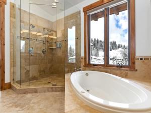 a bathroom with a tub and a shower with a window at Apex Lodge SOL-12011 in Salt Lake City
