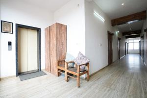 a room with a wooden chair and a hallway at ANTRA STAY by ASHOKA GROUP in Udaipur