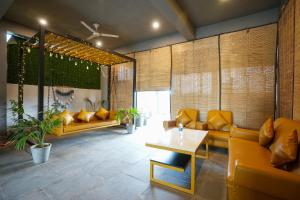 a living room with yellow couches and a table at ANTRA STAY by ASHOKA GROUP in Udaipur