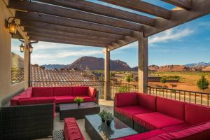 a patio with red couches and a view of the desert at Paradise Poolhouse STG-3800 in Santa Clara