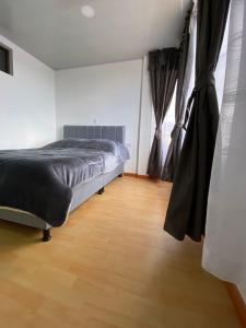 - une chambre avec un lit et du parquet dans l'établissement San Gabriel II - I, à Paipa