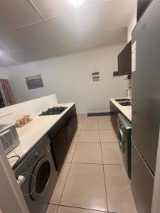 a kitchen with a washer and dryer in it at A little sanctuary in Edendale