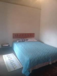 a bedroom with a bed with a blue comforter at Casa 27 in Antigua Guatemala