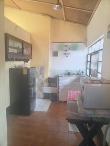 a kitchen with a black refrigerator and a sink at Casa 27 in Antigua Guatemala