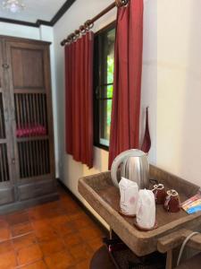 una camera con tavolo e bollitore per il tè. di The Royal Shilton Resort a Chiang Mai