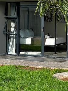 a bedroom with a bed inside of a glass door at SUumthing Private GuestHouse in Lebowakgomo