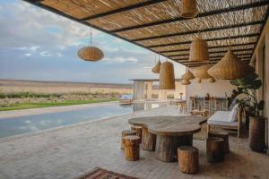 een patio met een tafel en een zwembad bij Villa S in Marrakesh