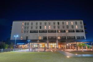 a large building with a lot of windows at night at Airport Hotel Kumamoto in Ozu