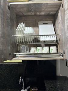 ein Regal mit einem Haufen weißer Gerichte in einer Küche in der Unterkunft Apartamento en Bello Medellín in Bello