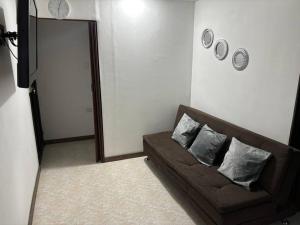 ein Wohnzimmer mit einem braunen Sofa mit zwei Kissen in der Unterkunft Apartamento en Bello Medellín in Bello