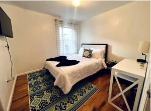 a bedroom with a bed and a desk and a window at Cozy 3BR Stay, EZ Access to NYC in Newark