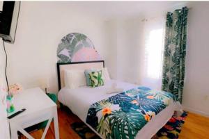 une chambre avec un lit, une table et une fenêtre dans l'établissement Cozy 3BR Stay, EZ Access to NYC, à Newark 2 autres photos