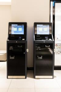 two printers with screens on them in a room at HOTEL NEXUS Hakata Sanno in Fukuoka