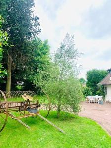 eine Parkbank im Gras neben einem Baum in der Unterkunft Villa de 5 chambres avec piscine privee jardin clos et wifi a Firfol in Firfol