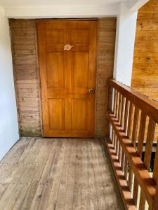 an empty room with a wooden door and stairs at Ecogreen Hotel - San Cipriano in San Cipriano
