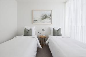 ニューカッスルにあるAmaya - 2 bed optionの白い壁と窓のある部屋にベッドが2つある +10枚の写真