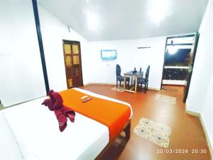 a bedroom with an orange bed and a dining room at SNS Beach Side Stay CALANGUTE in Calangute