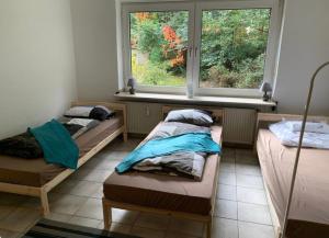 two beds in a room with a window at Ferienwohnungen mit Parkplätzen in Oberhausen