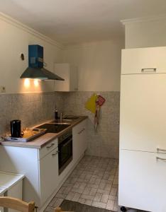 a kitchen with a sink and a white refrigerator at Ferienwohnungen mit Parkplätzen in Oberhausen
