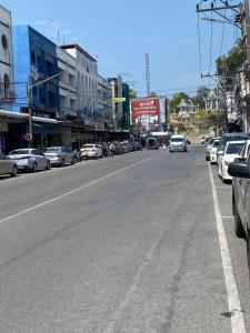 een straat met auto's aan de kant van de weg bij Saran Hostel krabi Thailand in Krabi town
