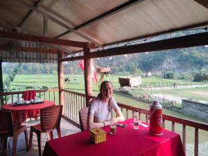 a man sitting at a table with a red table cloth at Tran Xuan Homestay in Ba Be18