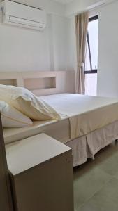 a bedroom with a bed and a window at Flat Reserva do Porto - Centrinho de Porto de Galinhas in Porto De Galinhas +9 photos