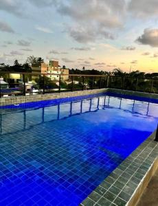 a large blue swimming pool on top of a building at Flat Reserva do Porto - Centrinho de Porto de Galinhas in Porto De Galinhas