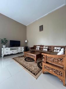sala de estar con sofás y TV de pantalla plana. en Villa Cijeruk Village, en Cihideung