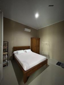 1 dormitorio con 1 cama grande con sábanas blancas en Villa Cijeruk Village, en Cihideung