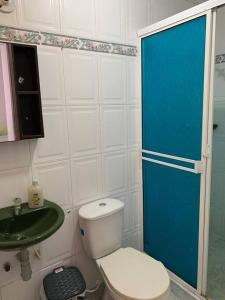 a bathroom with a toilet and a blue door at Apartamento en Cartagena cerca del aeropuerto in Cartagena de Indias