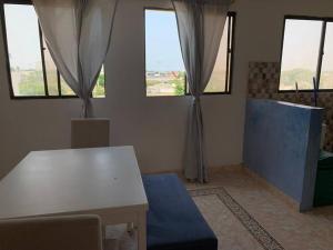 een woonkamer met een witte tafel en ramen bij Apartamento en Cartagena cerca del aeropuerto in Cartagena