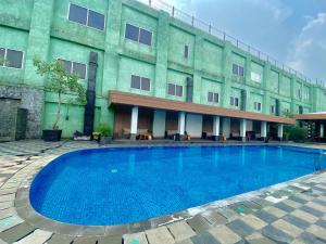 una gran piscina frente a un edificio en Whiz Prime Hotel Kelapa Gading en Yakarta