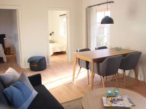 uma sala de estar com uma mesa de madeira e uma sala de jantar em 4 person holiday home in R nne em Rønne