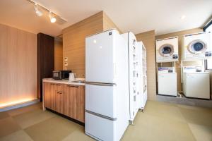 a kitchen with a white refrigerator and a counter at Hotel Base Nara in Nara