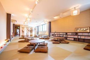 a library with tables and chairs and bookshelves at Hotel Base Nara in Nara