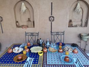 einen Tisch mit einem blauen Tischtuch mit Essen drauf in der Unterkunft Maison d'hôte tamatart - Homestay in El-Kelâa M’Gouna