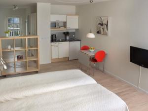 1 dormitorio con cama, mesa y cocina en 2 person holiday home in Gudhjem, en Gudhjem