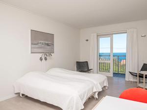 Habitación blanca con cama y balcón. en 2 person holiday home in Gudhjem, en Gudhjem