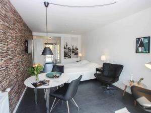 1 dormitorio con 1 cama, mesa y sillas en 2 person holiday home in Nex en Neksø
