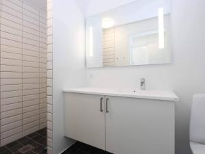 a white bathroom with a sink and a mirror at 2 person holiday home in Nex in Neksø