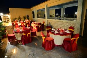 un restaurante con mesas y sillas rojas y amarillas en Goroomgo Coral Suites Puri Near Sea Beach with Swimming Pool - Parking Facilities, en Puri