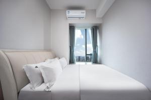 Cama blanca en habitación con ventana en Chengdu Yayu Aparthotel en Chengdú