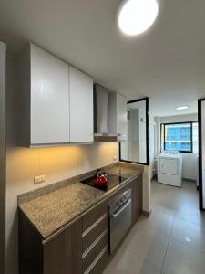 a kitchen with white cabinets and a counter top at ENCALADA 1233 LUXURY APARTS NEXT TO USA EMBASY - Surco in Lima