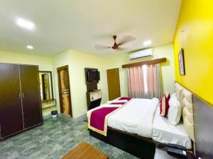 um quarto de hotel com uma cama e uma televisão em Goroomgo Coral Suites Puri Near Sea Beach with Swimming Pool - Parking Facilities em Puri