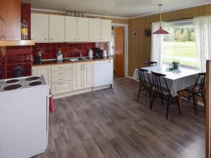 een keuken met witte kasten en een tafel met stoelen bij 8 person holiday home in Terr k in Terråk