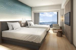 a hotel room with two beds and a large window at Courtyard by Marriott Fukui in Fukui