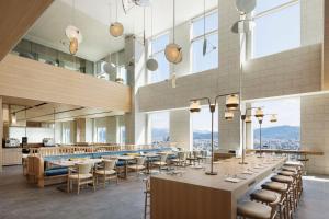un restaurante con mesas, sillas y ventanas grandes en Courtyard by Marriott Fukui en Fukui