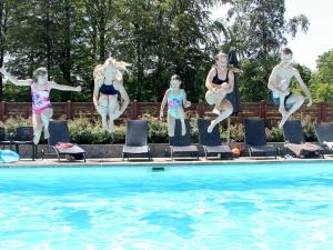 a group of people jumping into a swimming pool at 6 person holiday home in Hasle in Hasle