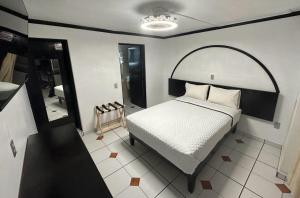 een slaapkamer met een groot bed en een spiegel bij HOTEL ZAPOTLAN in Ciudad Guzmán