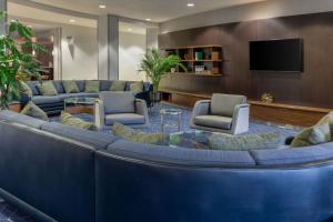 a lobby with a large blue couch and chairs at Courtyard by Marriott Ontario Rancho Cucamonga in Rancho Cucamonga